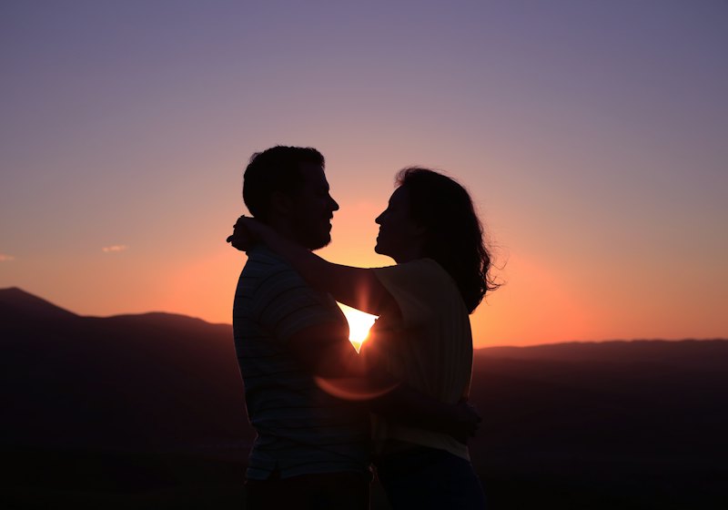 Silhouette of a couple embracing at sunset